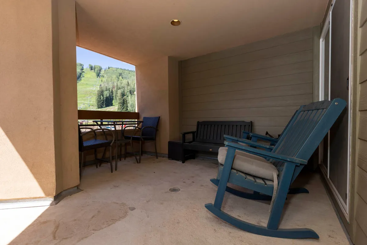 This interior shot features a tranquil seating area with a rocking chair and a clear view to the outdoors. The scene is inviting for relaxation and conversation after a busy day enjoying the village.